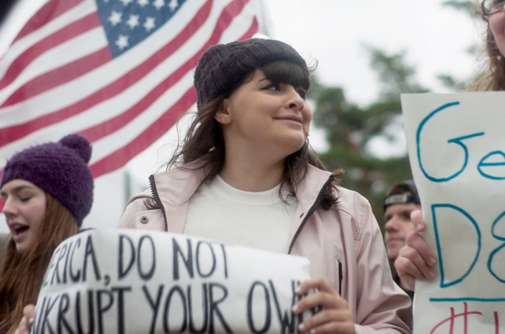 <p>International relations freshman Eloise Mitchell holds a sign and marches during the Million Student March on Nov. 12, 2015 at the Rock on Farm Lane. Throughout the protest, participants marched around campus demanding increased campus wide minimum wage, tuition-free education and the cancellation of student debt. </p>