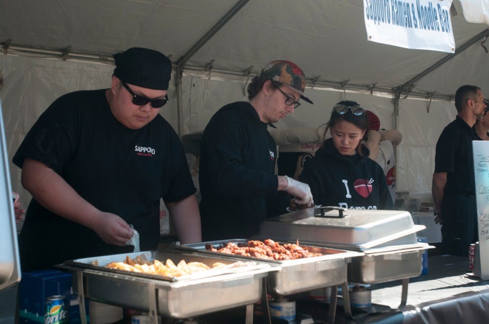 East Lansing resident Charlie Hoang, left, and East Lansing resident Tyler Ostrowski dish out food for peopleon April 23. 2016 at the Taste of East Lansing at 200 Albert Avenue. 