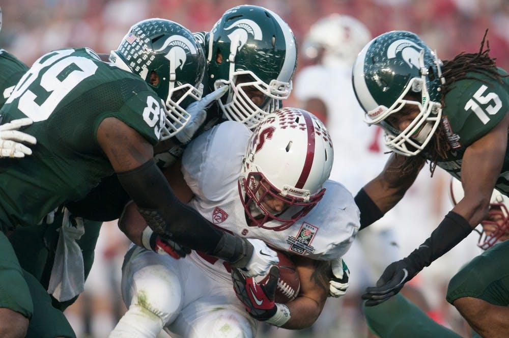 	<p>Sophomore defensive end Shilique Calhoun, 89, senior defensive lineman Micajah Reynolds and sophomore corner back Trae Waynes, 15, tackle Stanford running back Tyler Gaffney during the 100th Rose Bowl game Jan. 1, 2014, in Pasadena, Calif. The Spartans defeated the Cardinal, 24-20. Julia Nagy/The State News</p>