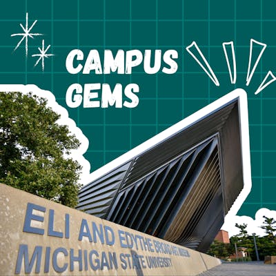 A modern, angular building with metal siding and a stone base features clear signage, surrounded by trees and a grid background.
