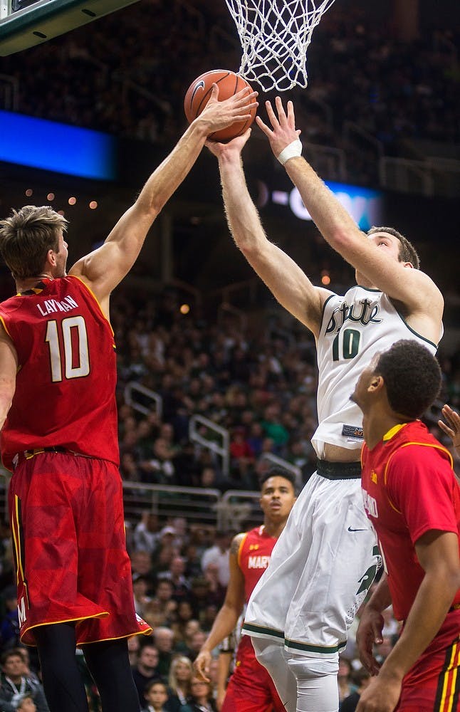 <p>Junior forward Matt Costello jumps up for a shot defended by Maryland forward Jake Layman on Dec. 30, 2014, at Breslin Center. The Spartans were defeated by the Terrapins, 68-66 in double overtime. Danyelle Morrow/The State News</p>
