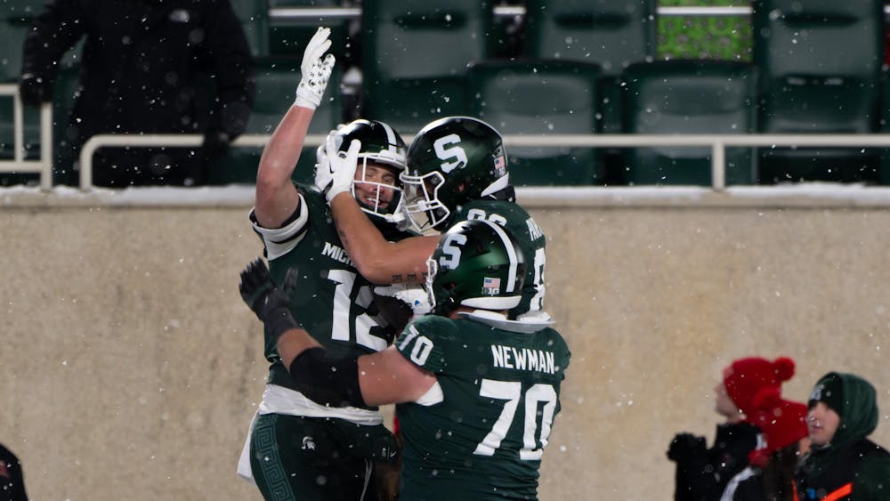 <p>MSU junior tight end Jack Velling (12) celebrates a touchdown with sophomore tight end Brennan Parachek (82) and fifth-year offensive lineman Luke Newman (70) at Spartan Stadium on Nov. 30, 2024.</p>