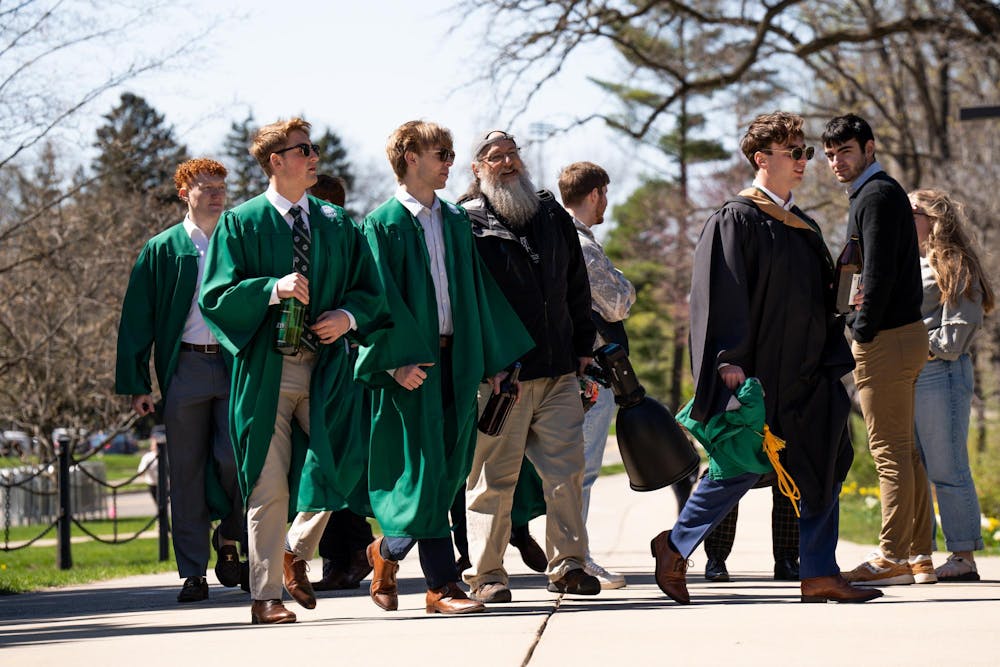 <p>A group of Michigan State University Seniors walk with a photographer to have their portraits taken on campus on April 19, 2024. Seniors often have to wait in line for the best spots on campus to have their portraits taken.</p>