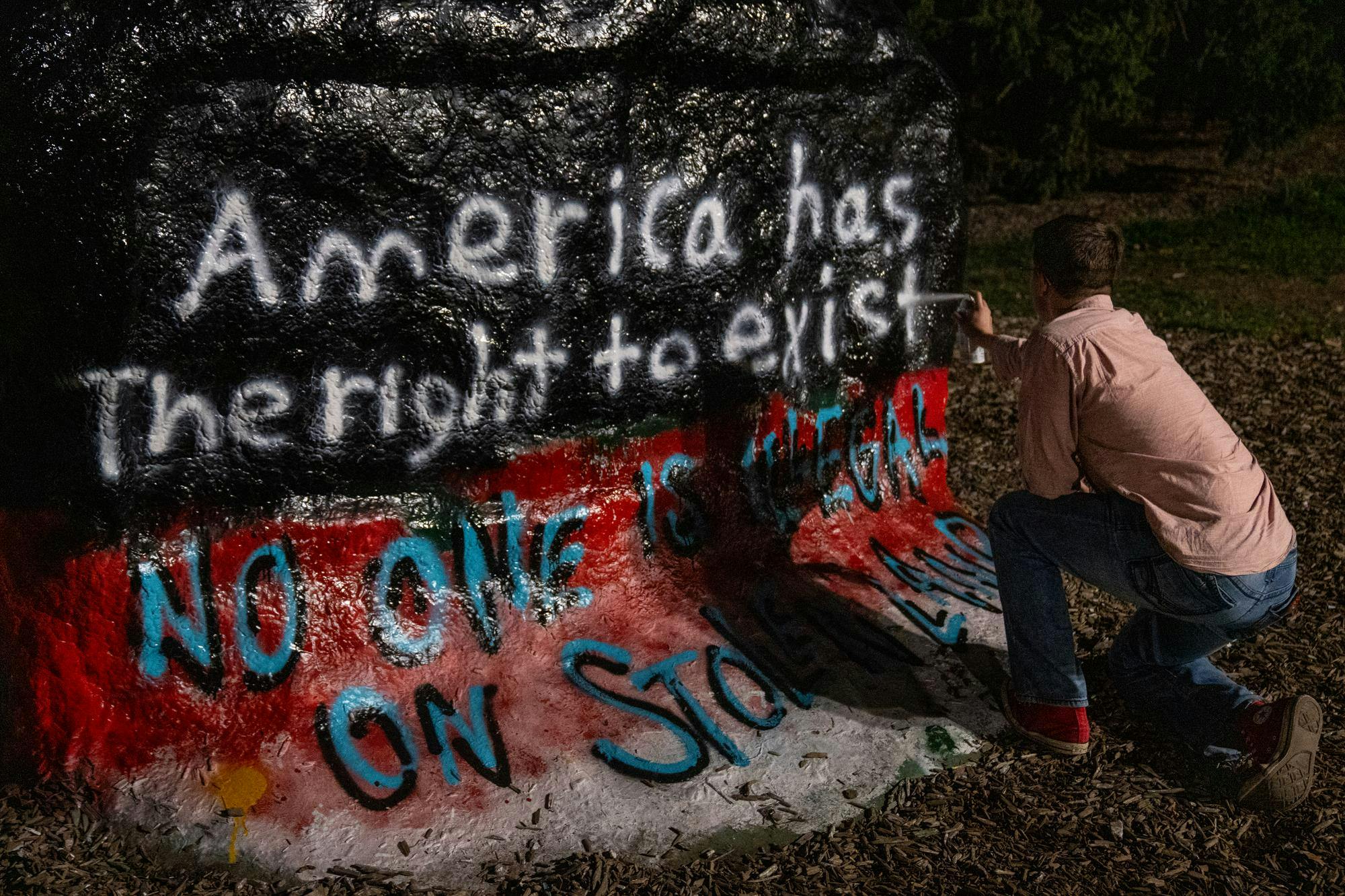<p>MSU student and Secretary of the MSU College Republicans Club, Tyler Bommarito, paints over The Rock, previously painted by the North American Indigenous Student Organization (NAISO) for Indigenous Peoples Day, on Michigan State University's campus in East Lansing on Monday, Oct. 13, 2025.</p>