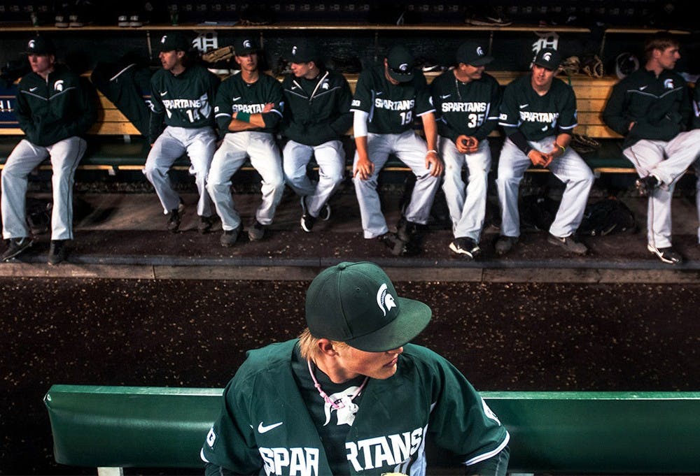 <p>Then-freshman left fielder Cam Gibson sits in the dugout with teammates behind him during a rain delay Wednesday, April 17, 2013, at Comerica Park in Detroit.</p>