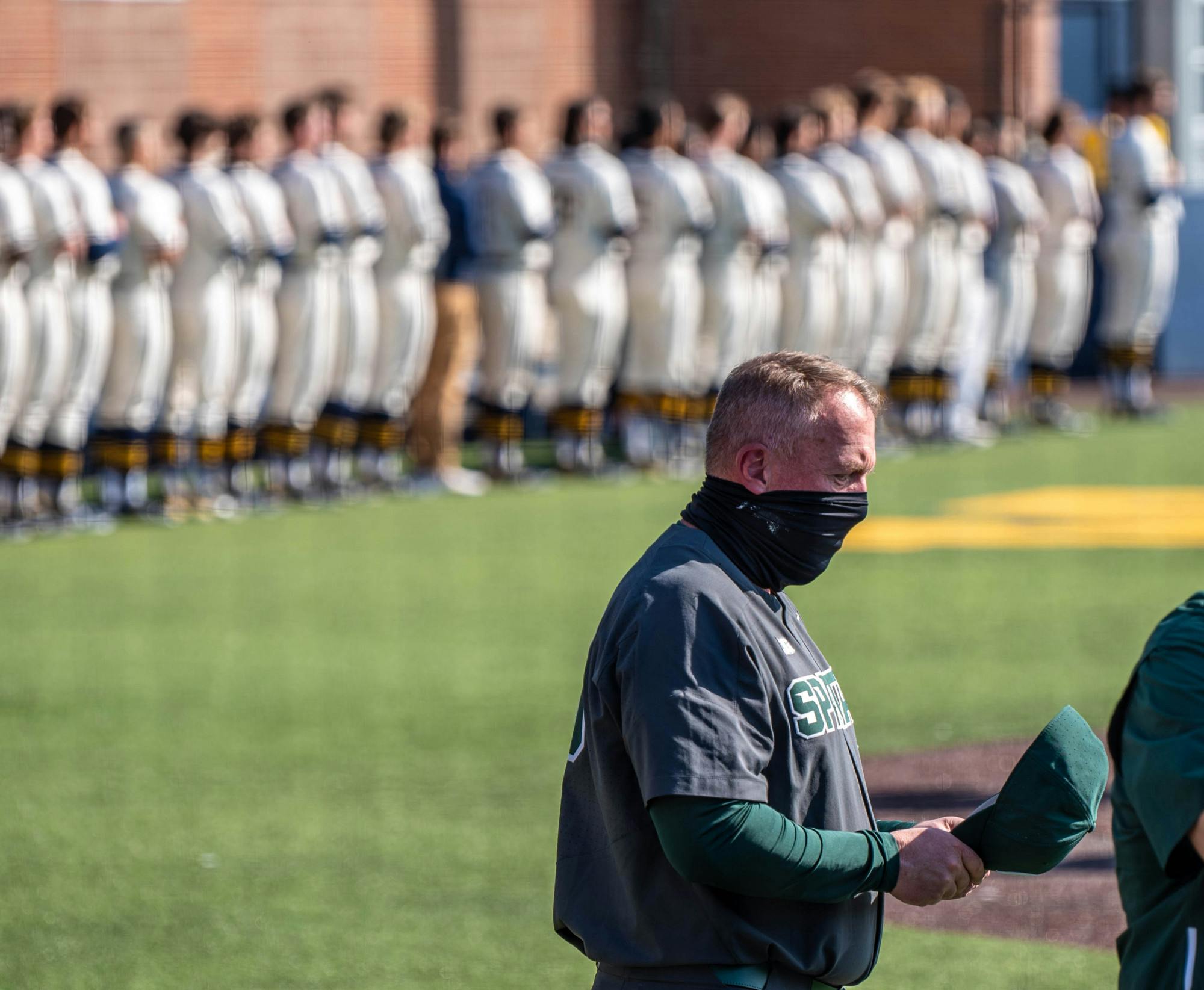 <p>Coach Jake Boss Jr. puts his hat back on after the national anthem. The Wolverines made a comeback in the ninth inning to top the Spartans 8-7 at Ray Fisher Stadium on March 21, 2021.</p>