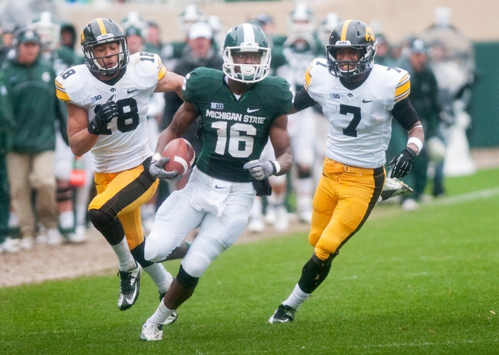 <p>Then-freshman wide receiver Aaron Burbridge runs from Iowa defensive backs Micah Hyde, left, and Sean Draper. Burbridge contributed 89 yards in the Spartans' 19-16 loss to the Iowa Hawkeyes. James Ristau/The State News</p>