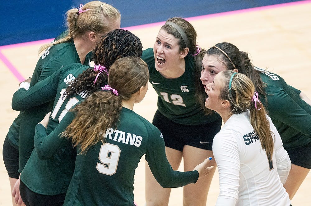 MSU volleyball players huddle together as junior setter Kristen Kelsay pumps up the team Wednesday night, Oct. 17, 2012, at Cliff Keen Arena in Ann Arbor, Mich. The Spartans defeated the Michigan Wolverines in three straight sets (25-20, 25-17, 25-20). Adam Toolin/The State News