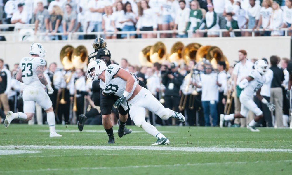 <p>Sophomore defensive end Kenny Willekes (48) falls from Western Michigan running back Jarvion Franklin (31) during the game against Western Michigan University on Sep. 9, 2017 at Spartan Stadium. Senior linebacker Chris Frey (23) is also pictured. The Spartans defeated the Broncos 28-14.</p>