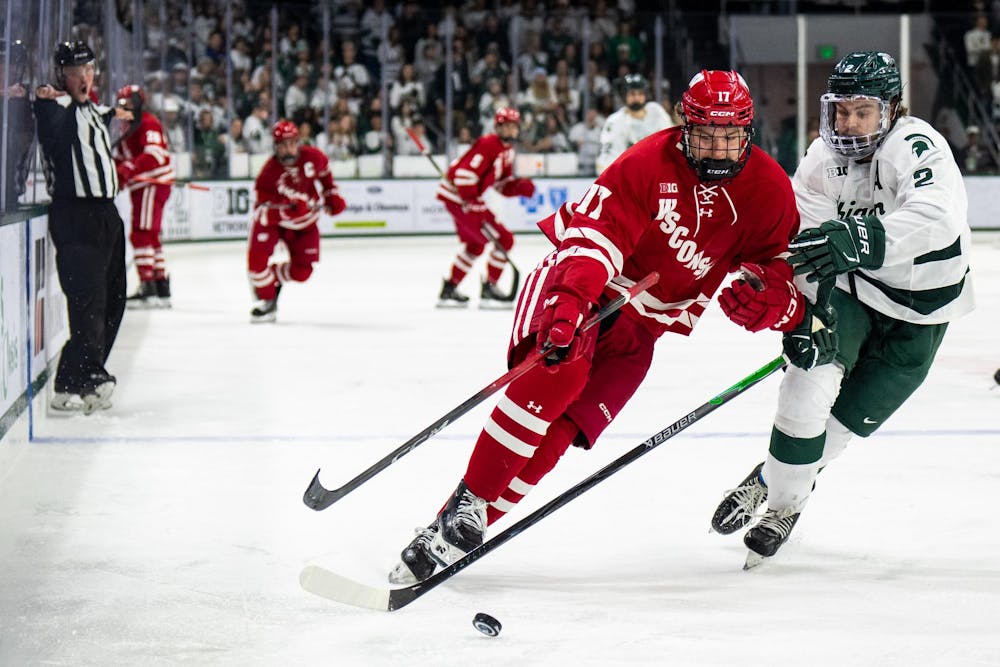 <p>Wisconsin forward Grady Deering (17) and Michigan State defenseman Patrick Geary (2) chase after the puck during a game between Michigan State and Wisconsin at Munn Ice Arena in East Lansing, Mich., on Saturday, Nov. 22, 2025.</p>