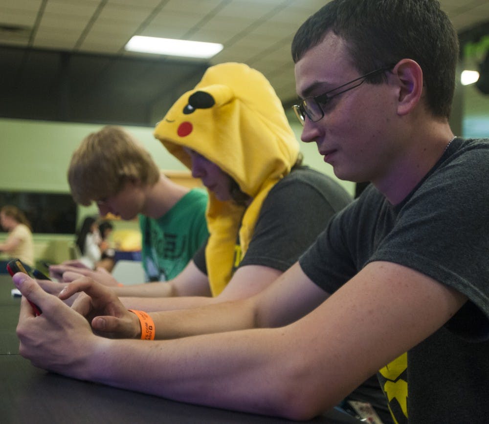 Out of town resident Tyler Mahaffa plays Pokemon Go during the Poke Pizza Party on Sept. 23, 2016 at the International Center.  The event featured free food, a photo booth and a screening of a Pokemon movie. 