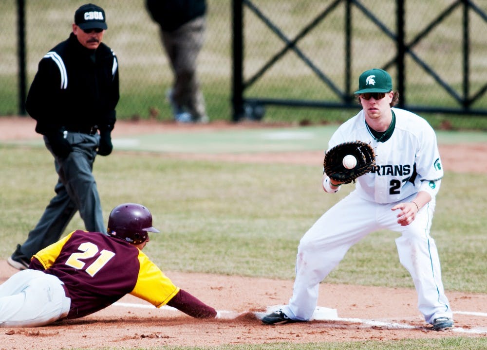 Senior first baseman Jeff Holm tries to catch Central Michigan infiedler Tyler Hall off the base. The Spartans lost to CMU, 3-1, on Wednesday at McLane Stadium at Kobb Field. Josh Radtke/The State News