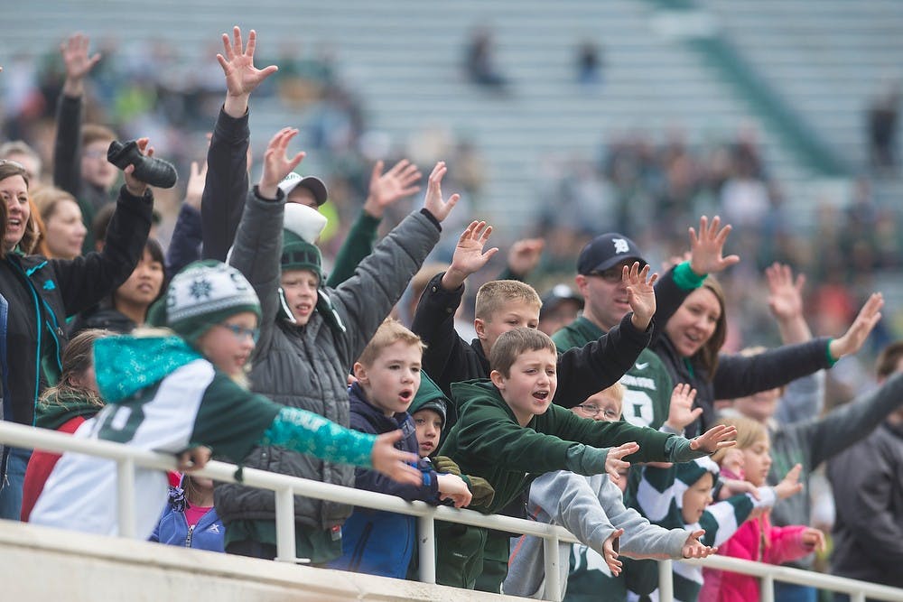 <p>Spartans fans cheer to win a shirt during the Green and White Spring game April 25, 2015, at Spartan Stadium. The white team defeated the green team, 9-3. Hannah Levy/The State News</p>