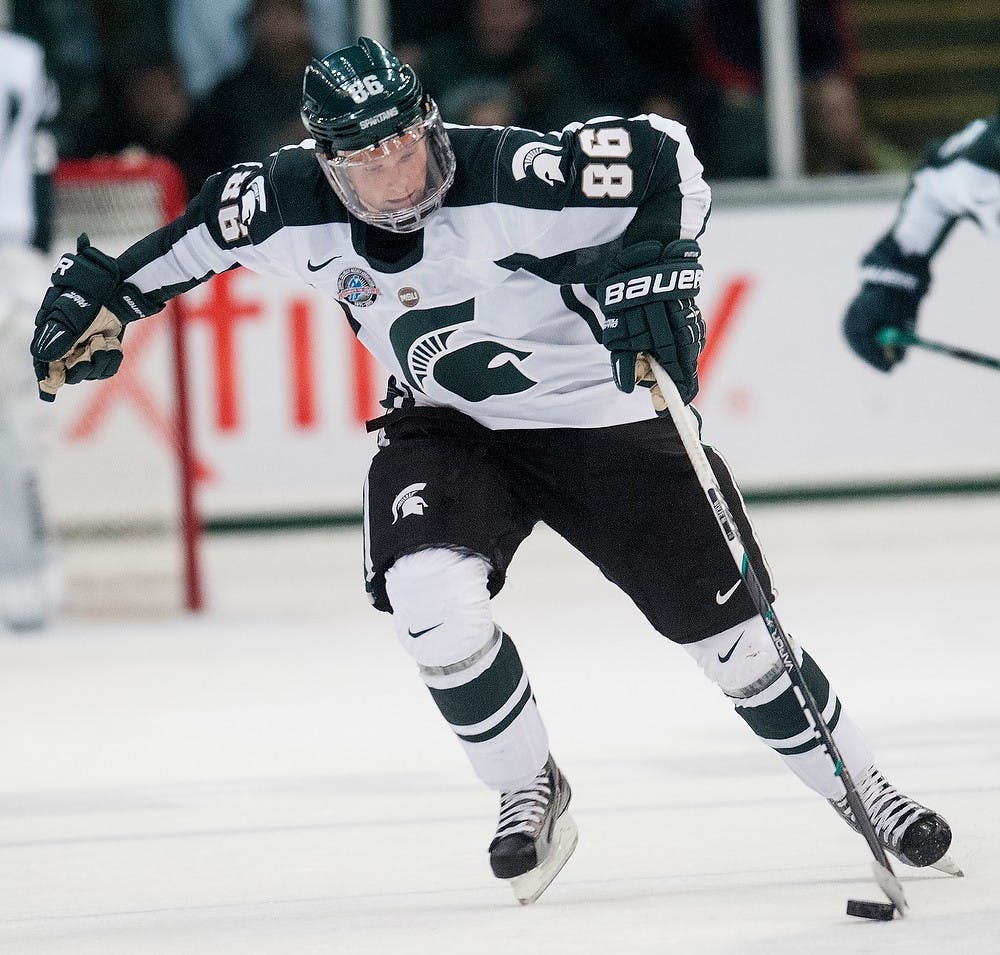 	<p>Junior forward Greg Wolfe skates the puck up the ice on Monday night, Oct. 8, 2012, at Munn Ice Arena. <span class="caps">MSU</span> defeated Windsor, 6-1in the first and only exhibition game. Adam Toolin/The State News</p>