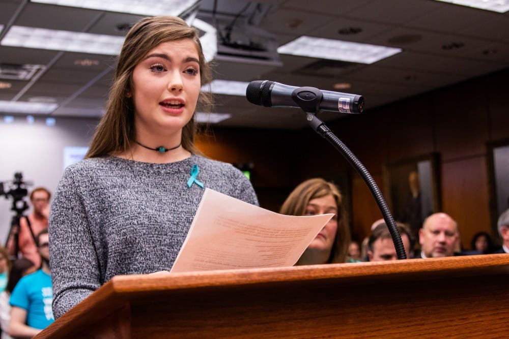 <p>Nassar survivor Emma Ann Miller speaks to the Board of Trustees during the public comment of the meeting Dec. 14, 2018 at the Hannah Administration Building.</p>