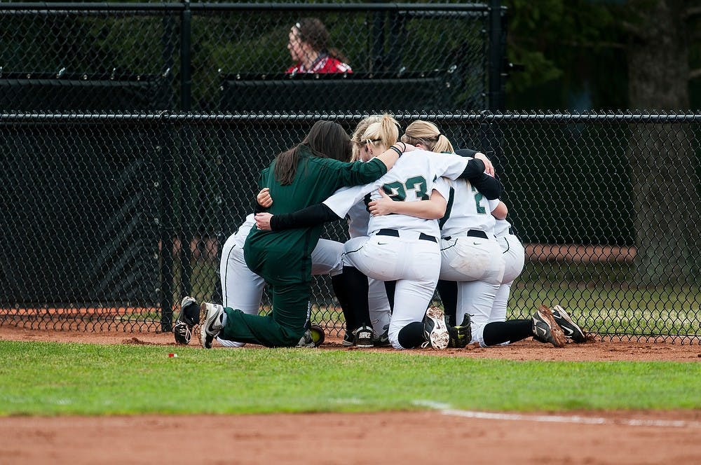 	<p>Members of the <span class="caps">MSU</span> softball team huddle together before the start of the game against Michigan April 14, 2013, at Secchia Stadium at Old College Field. The start of the game was delayed by an hour due to snow and rain. Katie Stiefel/The State News</p>
