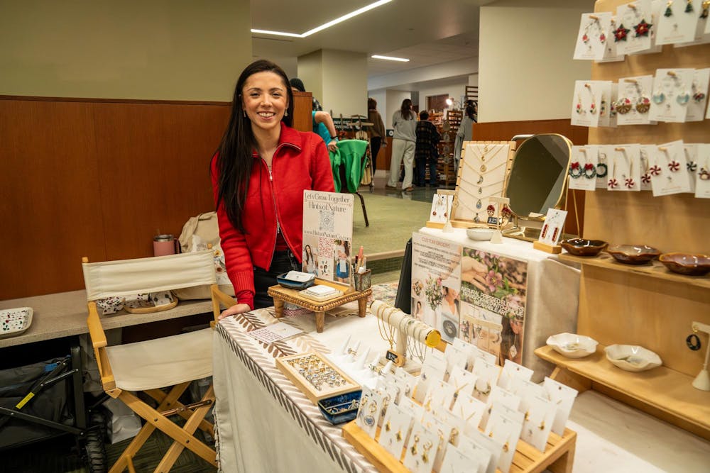 Nicole Collins stands at her table where she sells jewelry and accessories from her business, Hints of Nature, during Michigan State’s annual winter arts and craft show at the Union on campus in East Lansing, Mich., on Saturday, Dec. 6, 2025.