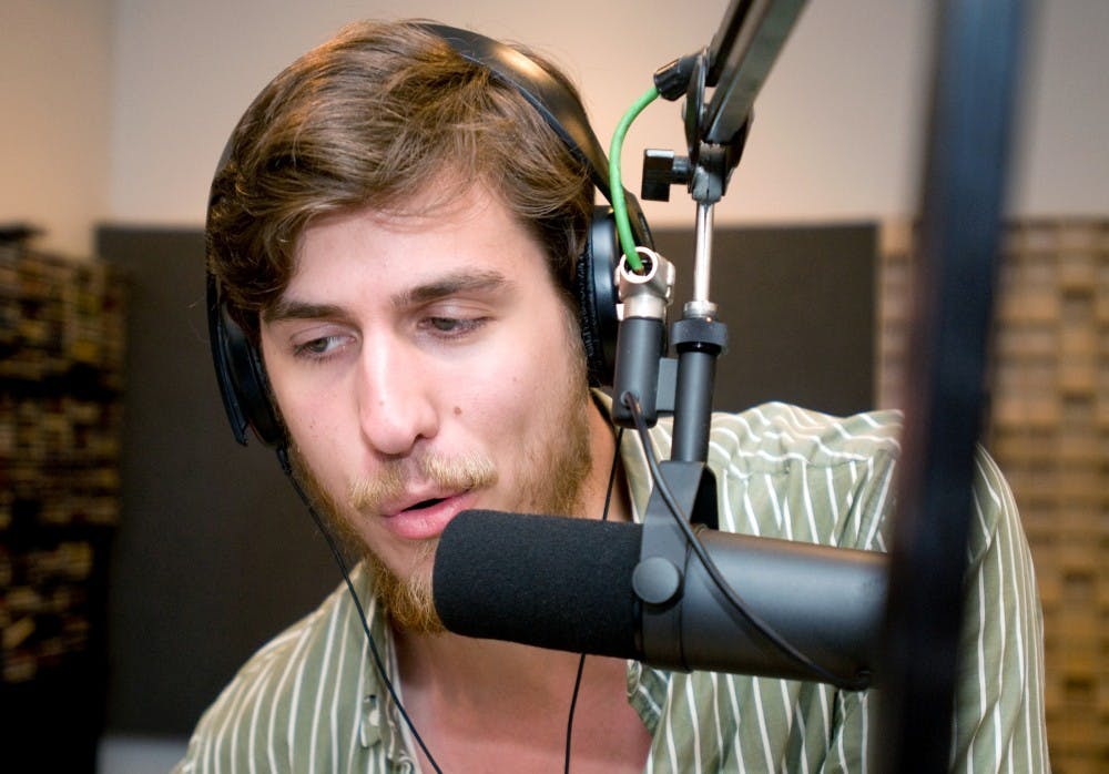 	<p>Dylan DeVries, then-senior in the Residential College of Arts and Humanities, talks to his audience between songs while he deejays on-air for Impact 89FM on June 6, 2011 in Holden Hall. The Impact has been named College Radio Station of the Year for 10 years running. State News File Photo</p>