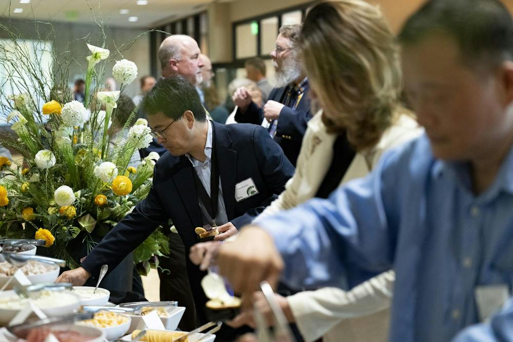 MSU Red Cedar Distinguished Professor Liangliang Sun of the Department of Chemistry fills a plate at the buffet at a reception following the 2026 State of the University Address at the Wharton Center for Performing Arts at MSU on Tuesday, Sep 29, 2026.