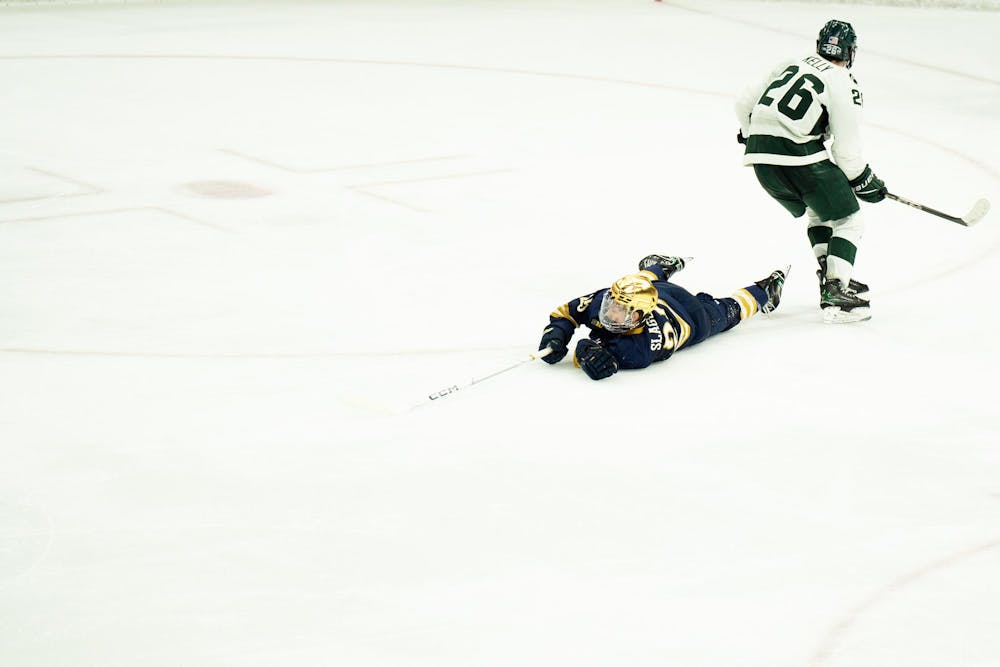 Notre Dame sophomore forward Carter Slaggert (25) falls on the ice at Munn Ice Arena on March 15, 2025. The Spartans took a 1-0 victory over the Fighting Irish, advancing to the Big Ten Championship.