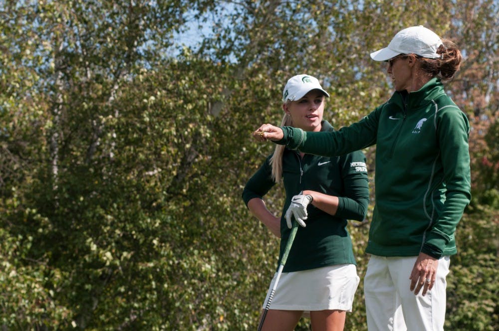 <p>Women's golf head coach Stacy Slobodnik-Stoll, right, talks with junior Sarah Burnham before a shot on Sept. 25, 2016 at Forest Akers West Golf Course. Slobodnik-Stoll has held the head coaching position at MSU for 19 years.&nbsp;</p>