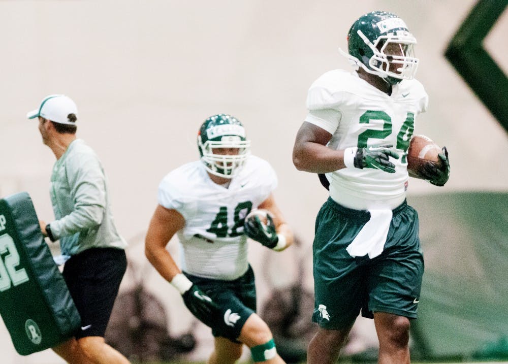 Junior runningback Le'Veon Bell, right, runs with the ball at a drill on Monday, Aug. 13, 2012 at Duffy Daugherty Football Building. Justin Wan/The State News