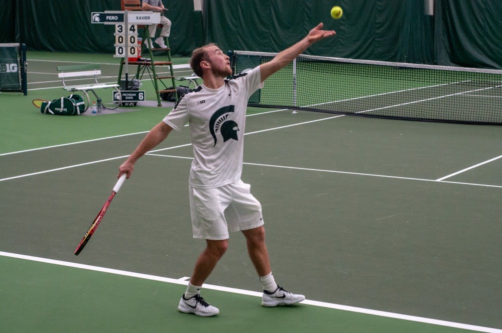 <p>Freshman Anthony Pero serves the ball during a singles match at the MSU Tennis Center on Jan. 12. Pero won his match.</p>