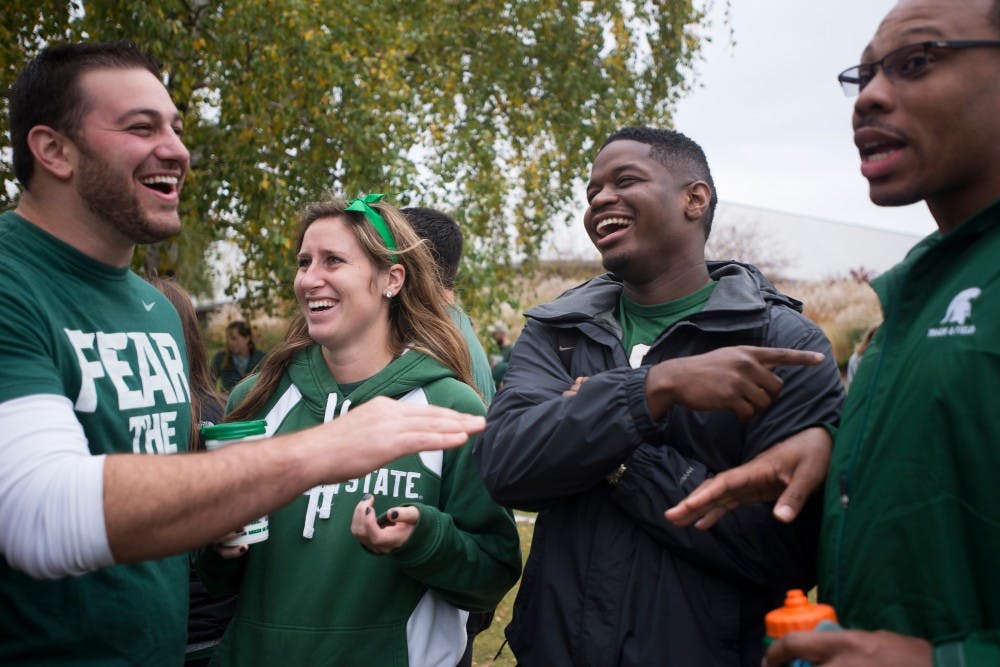 <p>From left to right, former track and field member and MSU alumnus Anthony Agrusa, South Bend, Ind., resident Lydia Brower, former track and field member and MSU alumnus Isaac Marshall and former track and field member and MSU alumnus Lonnie Pugh tailgate on Oct. 24, 2015, before the game against Indiana near Munn Ice Arena. </p>