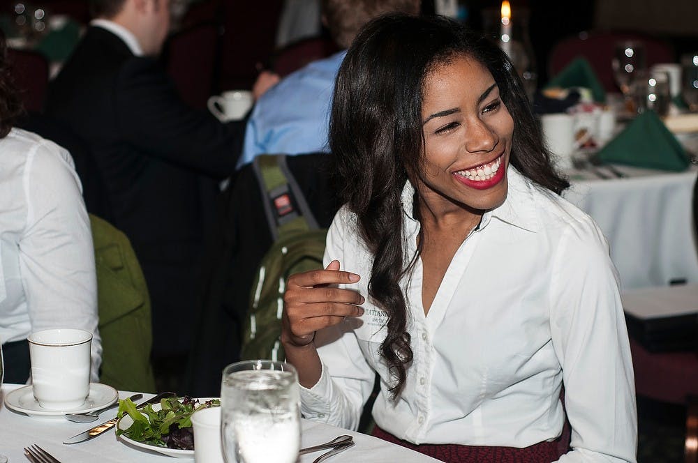 <p>Human biology junior Tatiana Smith laughs with her friends Feb. 26, 2014, during a MSU Federal Credit Union professional prep dinner for students at the MSU Union. The event was set up as a "mock" business dinner to learn proper etiquette. Erin Hampton/The State News</p>