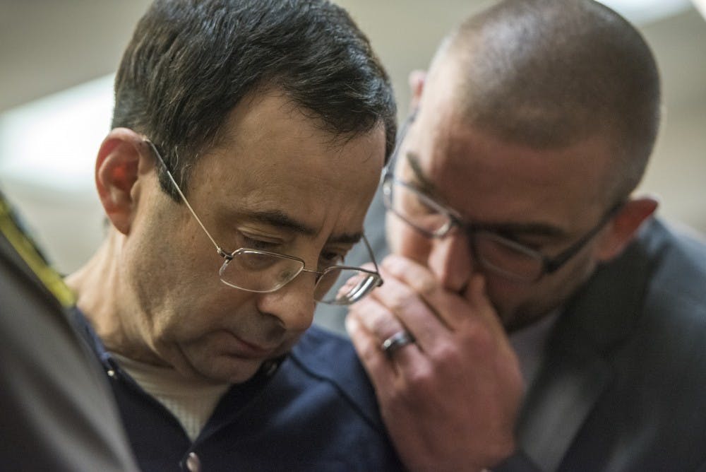 Ex-MSU and USA Gymnastics Dr. Larry Nassar talks with his attorney, Matt Newburg, on the fourth day of his sentencing on Jan. 19, 2018 at the Ingham County Circuit Court in Lansing. (Nic Antaya | The State News)