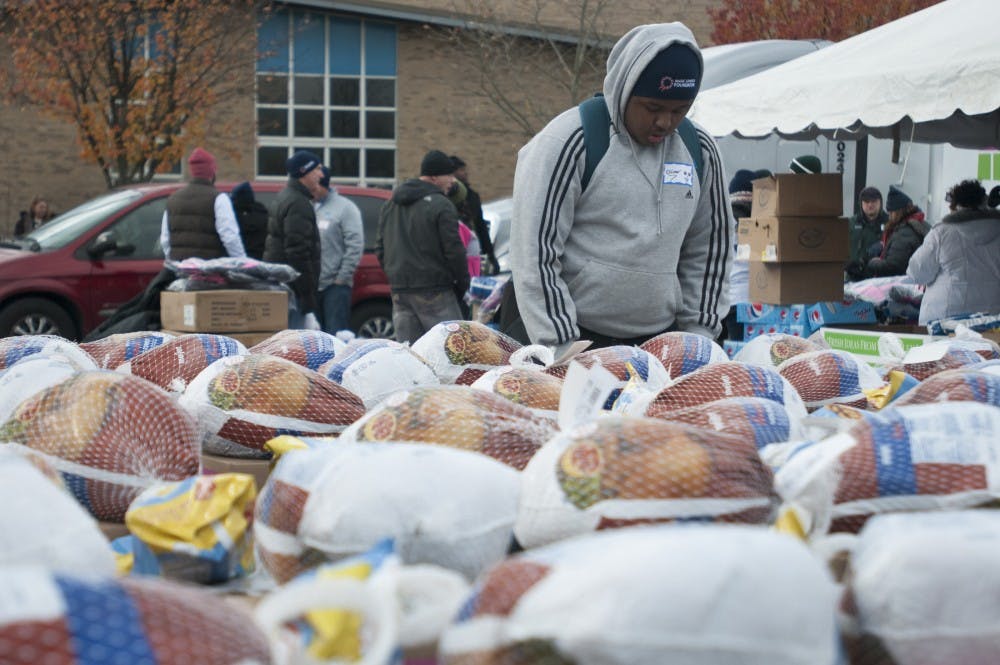 Lansing resident Oliver Williams sets up supplies on Nov. 20, 2016 at Everett High School in Lansing. Williams was helping at Holiday Hope Lansing which gives supplies to families in need.