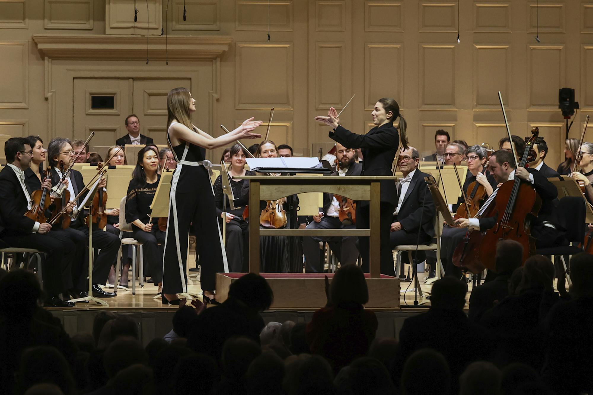 Composer Grace Evangeline Lily (left) and conductor Anna Handler (right) applaud each other.
