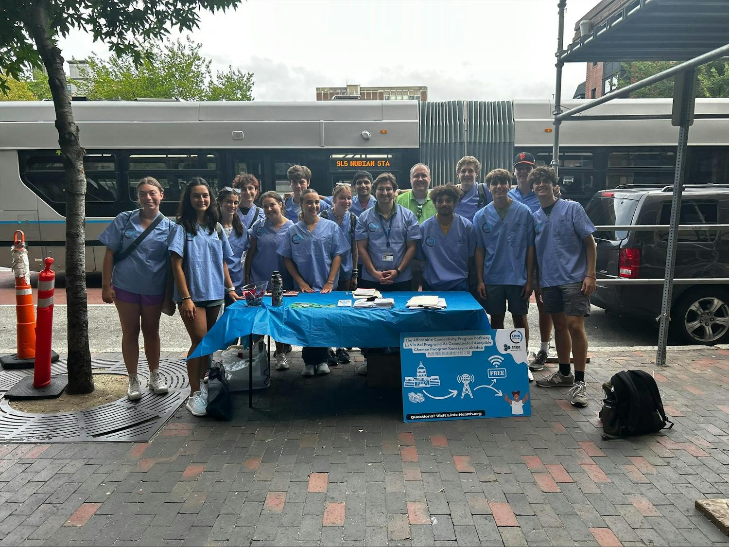 SHAPE pre-orientation program participants pictured standing in front of a table in the Boston community.