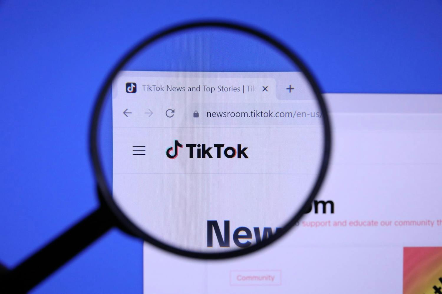 Homepage of TIKTOK Website magnified on logo with magnifying glass