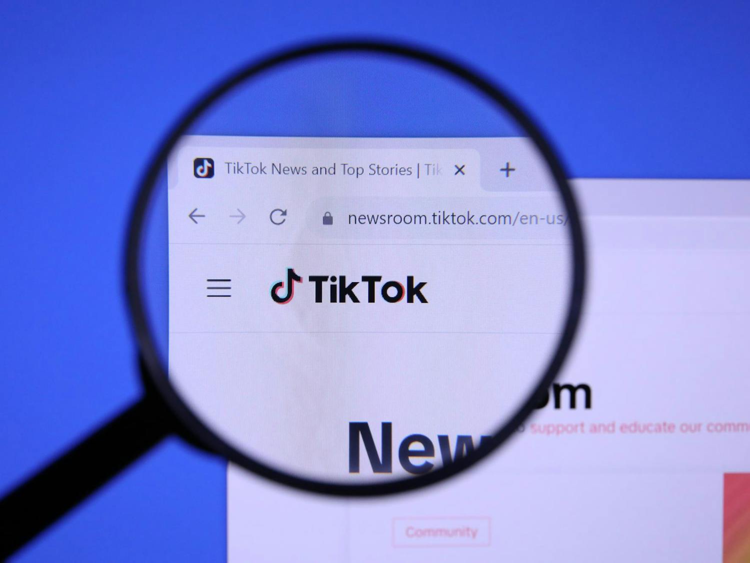 Homepage of TIKTOK Website magnified on logo with magnifying glass