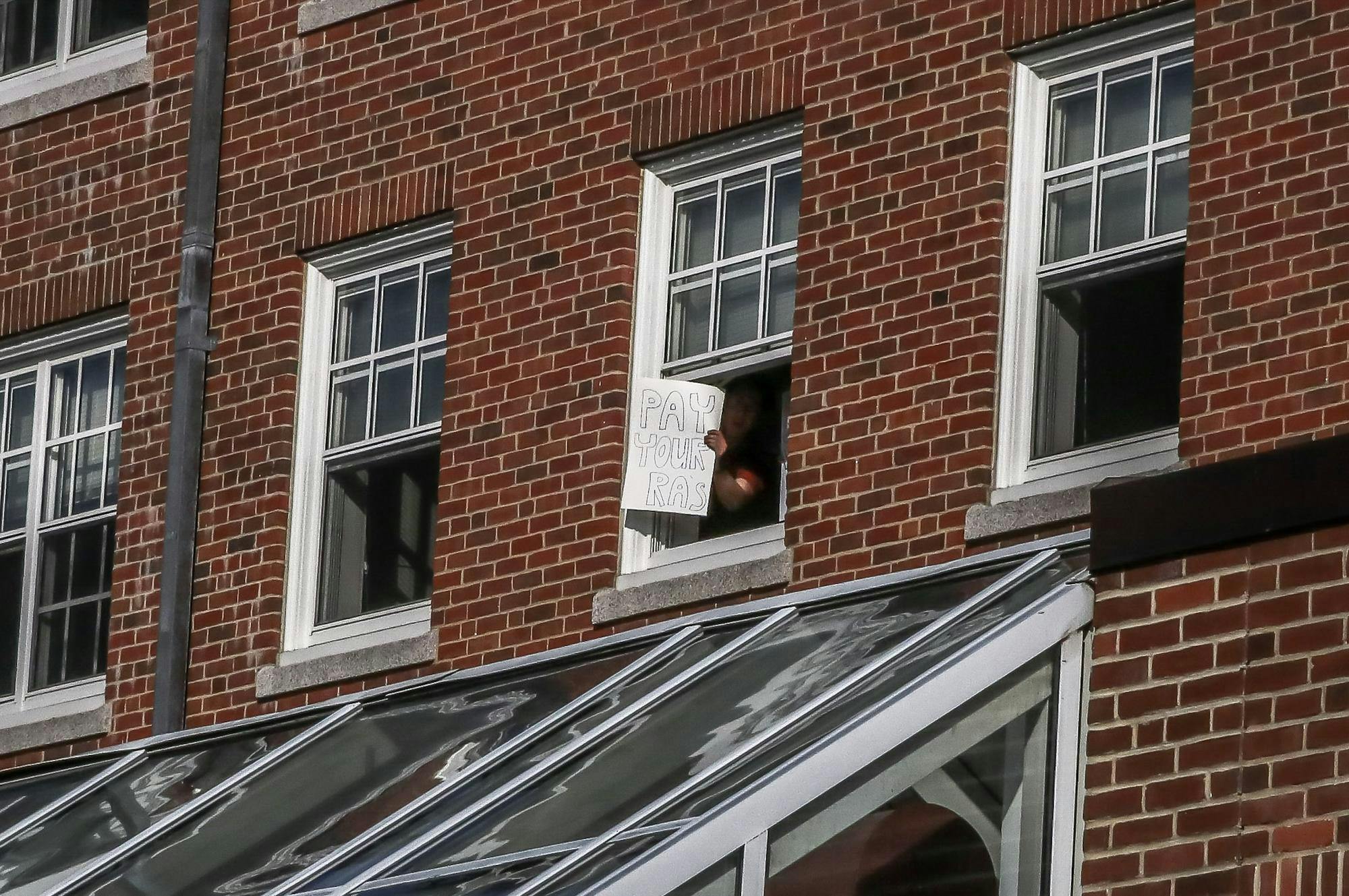 A student in Carmichael Hall holds a sign expressing support for RAs on Aug. 27. The sign reads: "Pay your RAs".