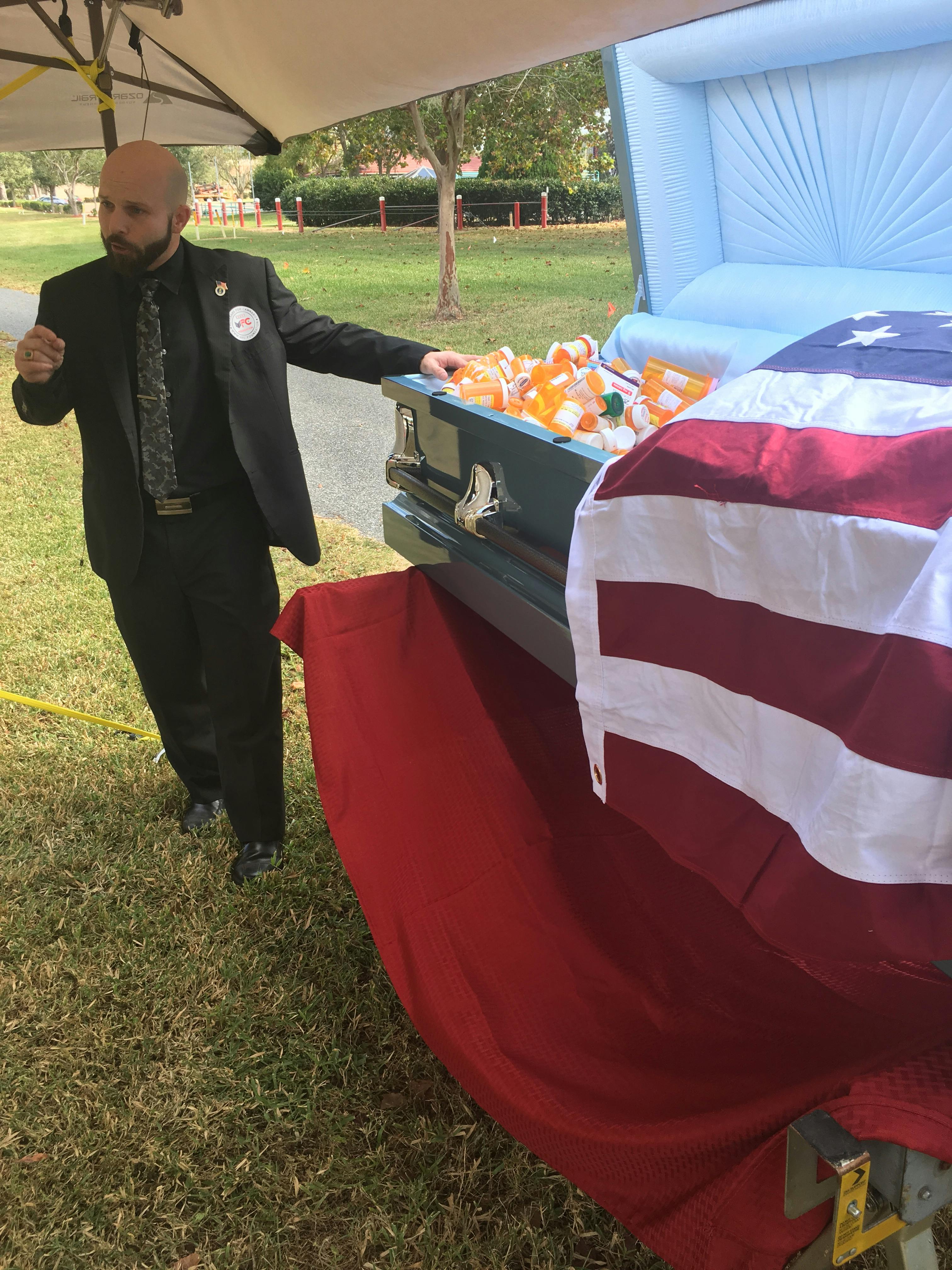 Veterans for Cannabis founder Joshua Littrell speaks about opioid deaths among veterans Saturday outside the Malcom Randall VA Medical Center, located at 1601 SW Archer Road. Littrell and four other veterans protested by filling a casket with empty prescription pill bottles. “Each one of these bottles is a brother and sister no longer with us,” he said. 