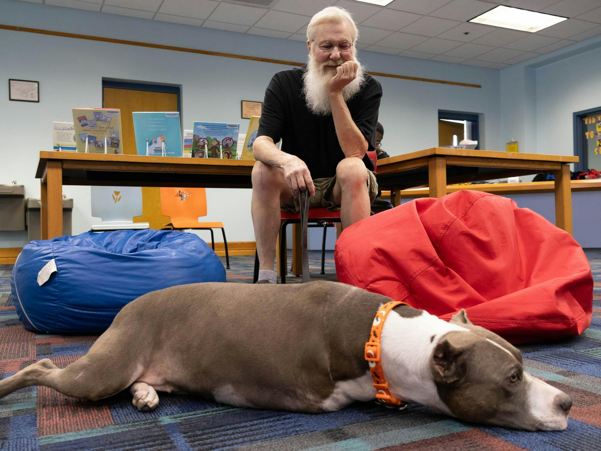 Dennis Pollard and his dog at the Read with a Dog program at Alachua County Millhopper Branch Library on Thursday, Oct. 17, 2025.
