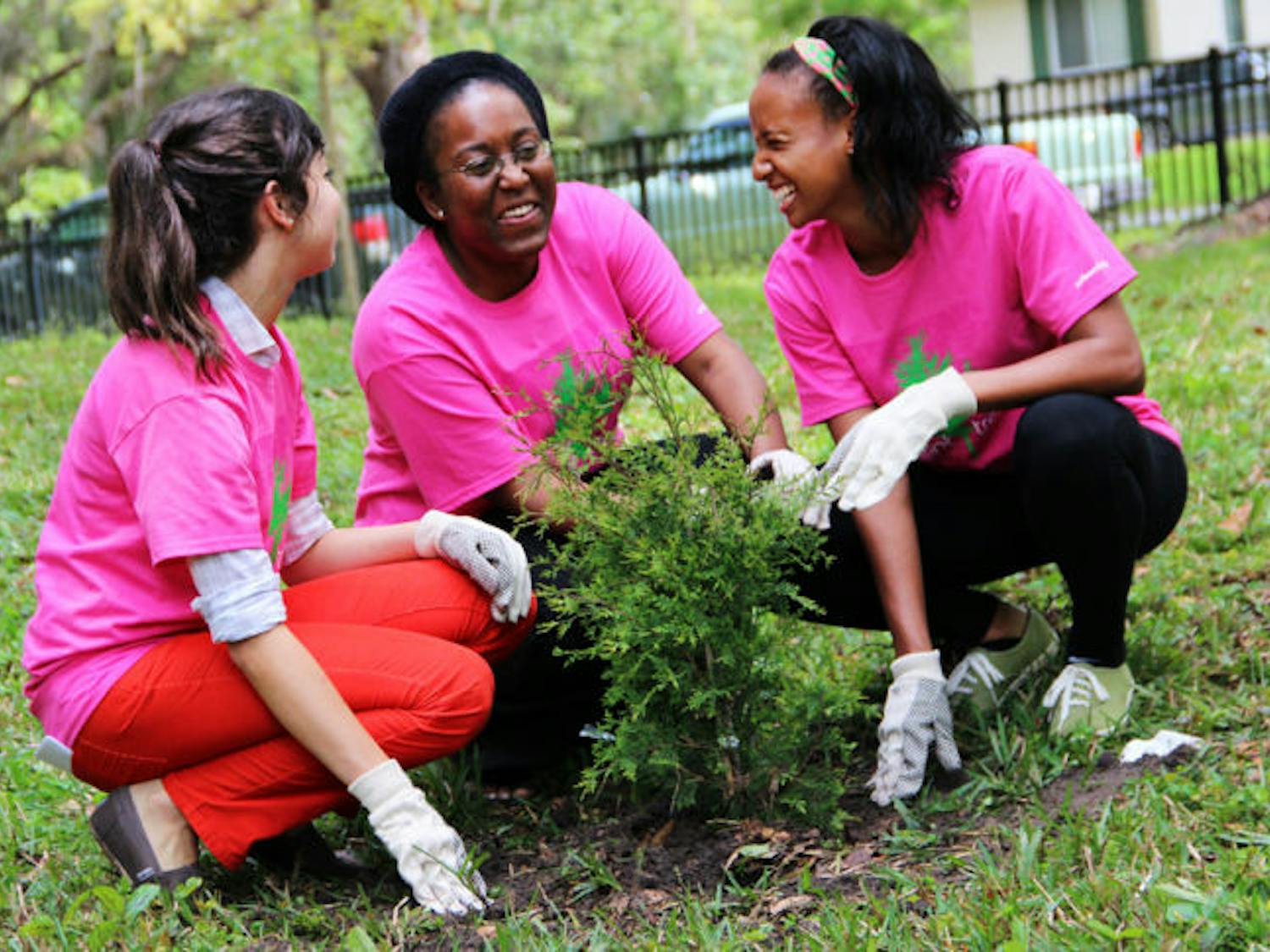 Taylor Cremo, 22, left, Shekinah Ellis, 21, center, and Monique Harris, 22, right, volunteer to plant trees near the President’s House as part of Tree Campus USA efforts.