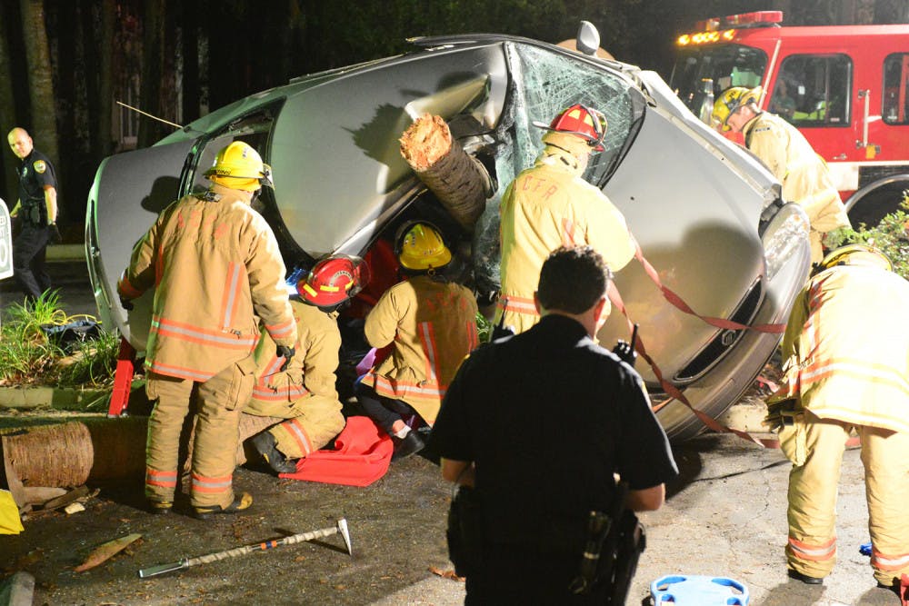 Alachua County Fire Rescue workers attempt to free Louis M. Penque Jr. from his car late Saturday. A witness said Penque attempted to pass her while traveling about 70 to 80 mph on Southwest 62nd Street.