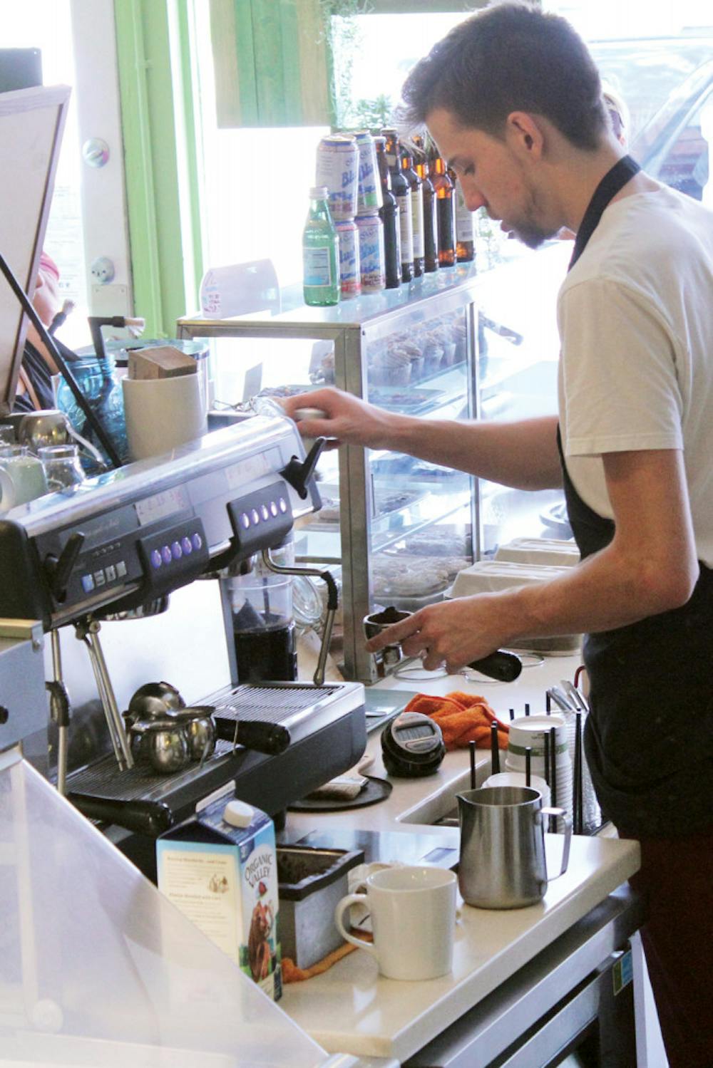 <p>Nick Bowden, 20, operates the new espresso machine at Karma Cream on Aug. 25, 2015. “It was time to get a replacement, and this one is so much better,” Bowden said.</p>