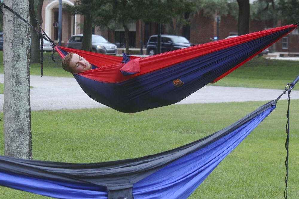 SLEEPING BEAUTY -- Charlie Le Grand, an 18-year-old UF biology major, naps at one of the hammocks during the third annual Trunks and Trashcans event on Saturday. Hosted by the UF Hammock club, the event was filled with hammocks, slacklines and Frisbees.