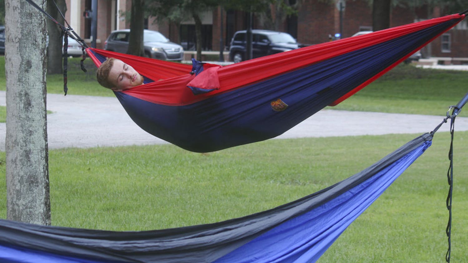 SLEEPING BEAUTY -- Charlie Le Grand, an 18-year-old UF biology major, naps at one of the hammocks during the third annual Trunks and Trashcans event on Saturday. Hosted by the UF Hammock club, the event was filled with hammocks, slacklines and Frisbees.