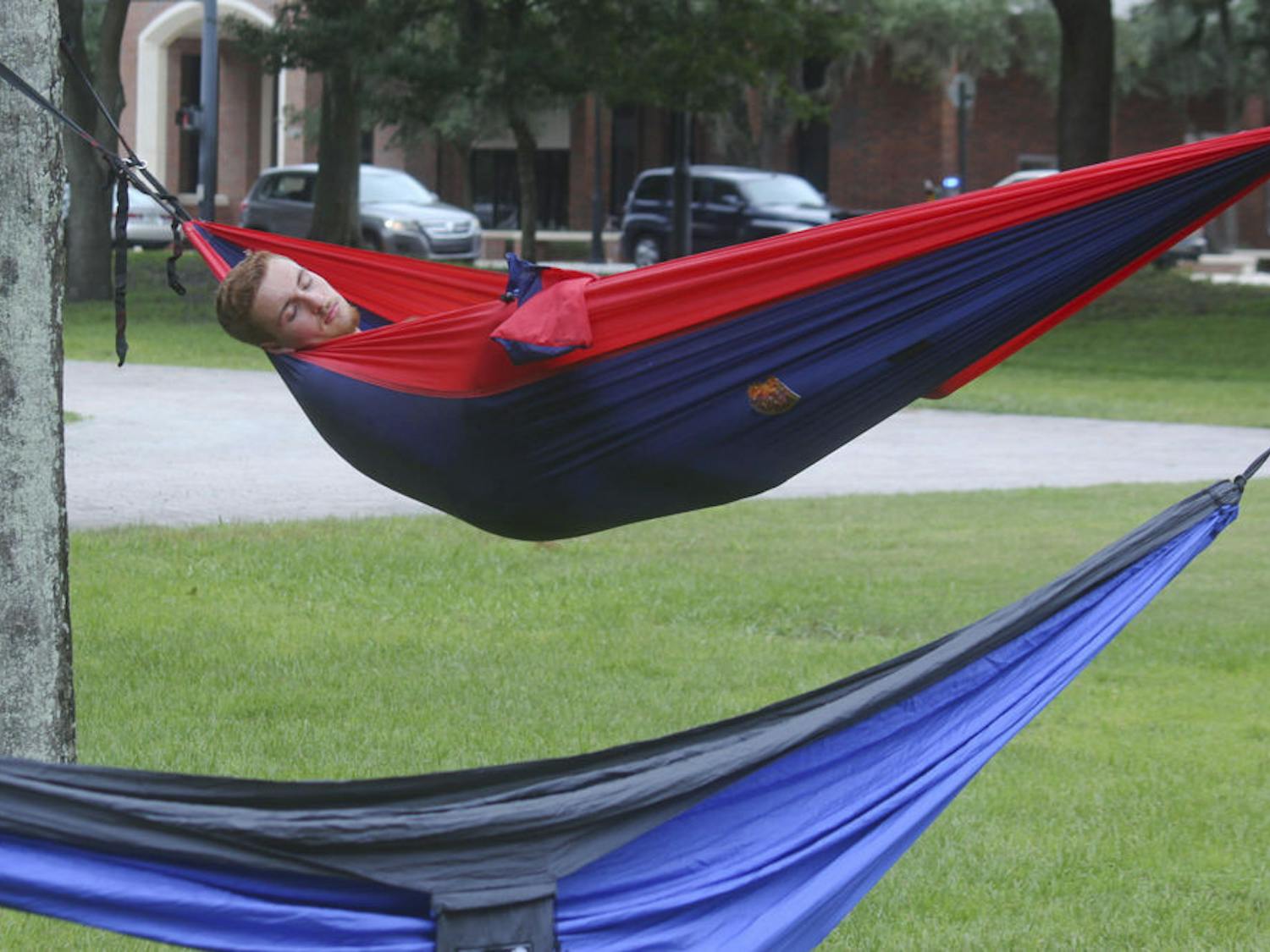 SLEEPING BEAUTY -- Charlie Le Grand, an 18-year-old UF biology major, naps at one of the hammocks during the third annual Trunks and Trashcans event on Saturday. Hosted by the UF Hammock club, the event was filled with hammocks, slacklines and Frisbees.