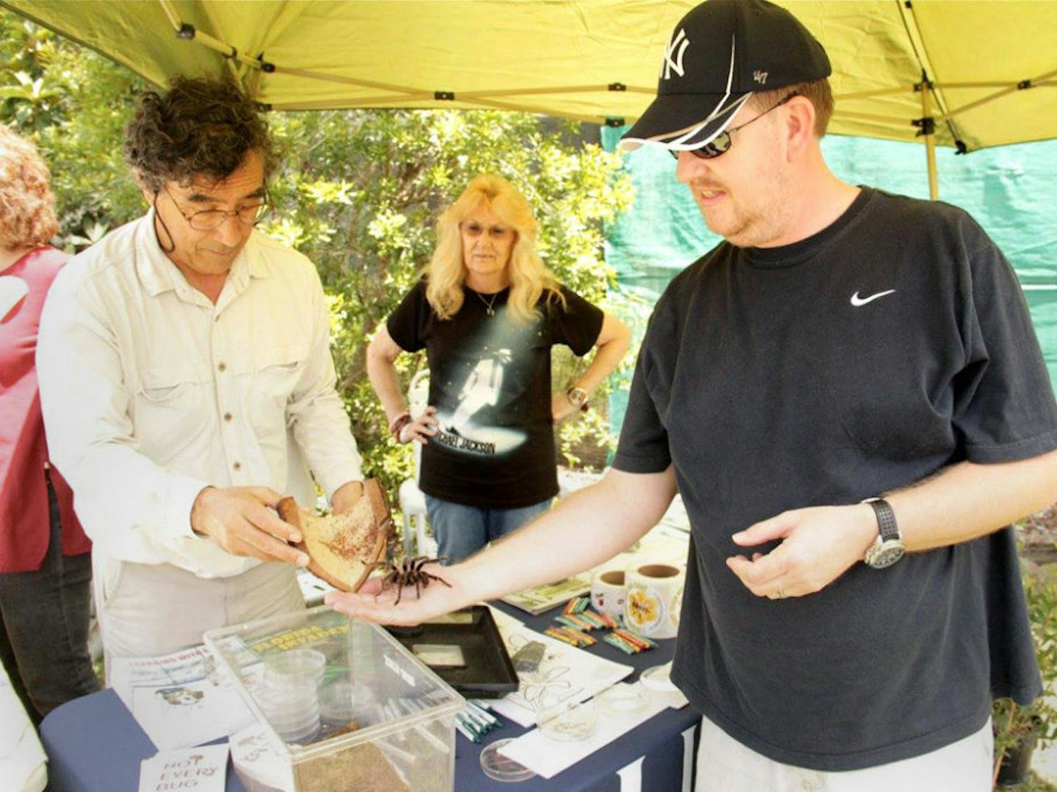 Dr. Joe Cicero, a UF research scientist, hands a tarantula to attendee Mark Xby in the booth for the UF Entomology and Nematology Outreach Program during the Endangered Species Awareness Day at the Lubee Bat Conservancy on Saturday. It was the first time Xby had held a tarantula.