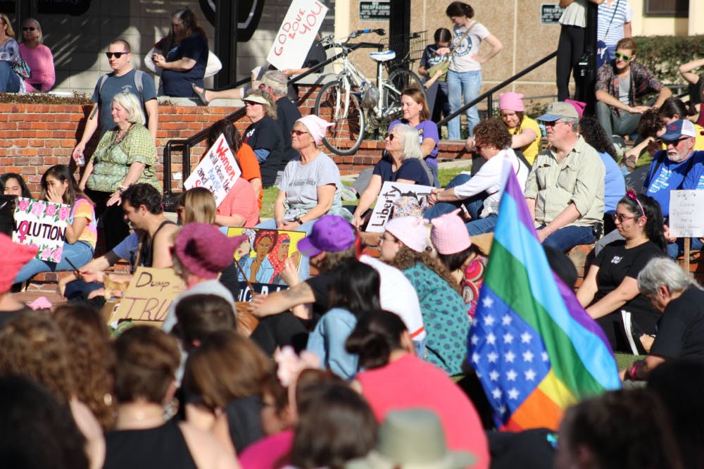 Protesters for the Women's Resistance movement gathered at Bo Diddley Plaza on Sunday before marching down West University Avenue to raise support for more female involvement in the American political process.