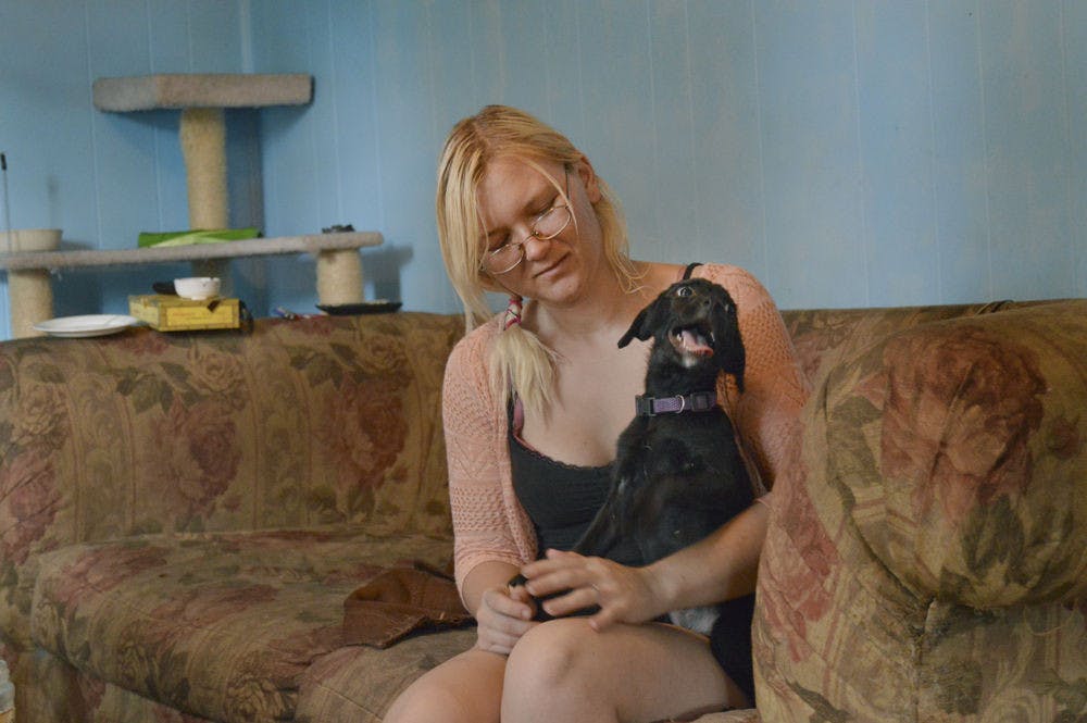 <p>Rebecca Pardini plays in her home with Angel, a puppy she's taking care of for a friend. The 22-year-old was homeless for three years.</p>