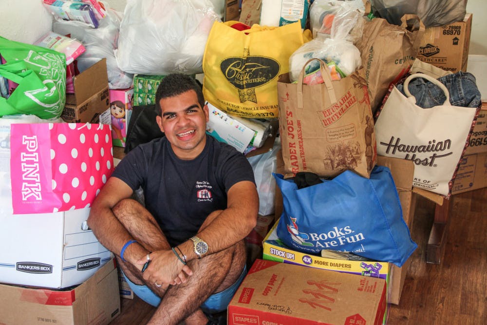 Amaury Sablon, a 20-year-old UF telecommunication and Spanish junior, stands in front of the money and supplies that were donated to bring to Haiti this weekend after Hurricane Matthew.