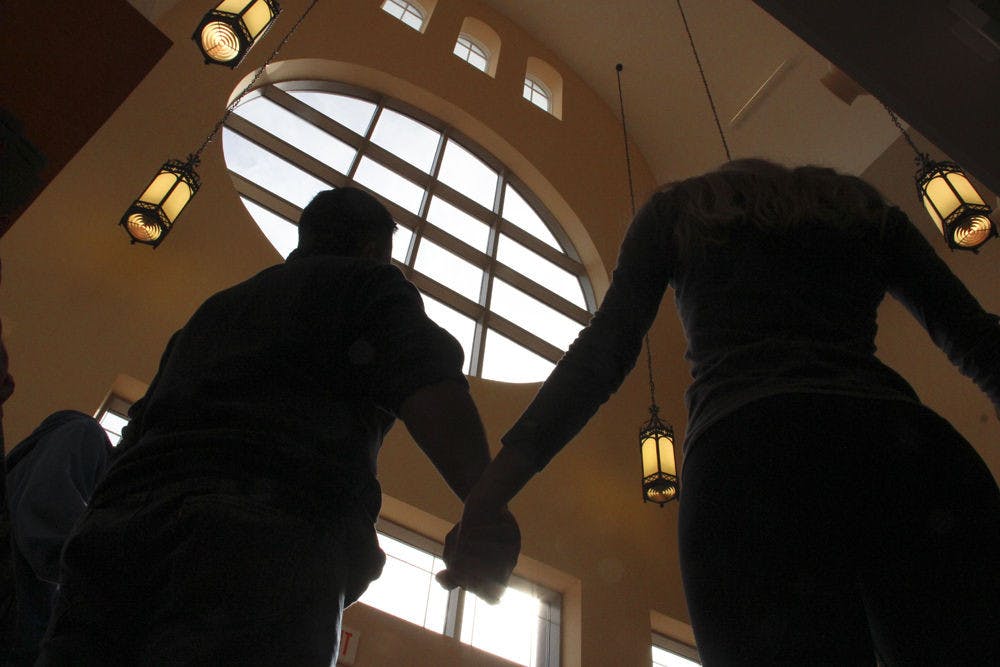 <p class="p1">Students and members of Gator Wesley Foundation on West University Avenue hold hands and pray Thursday afternoon. The prayer vigil was held in response to the Florida State University shooting Thursday morning.</p>