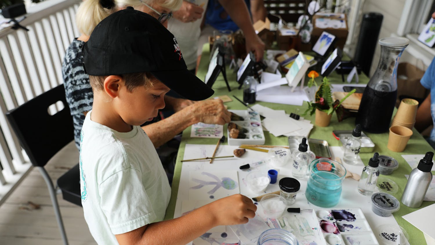 Dylan Perez, 6, uses blue butterfly flower pigment to paint on reusable paper at an eco-art event on Saturday, June 12, 2021. 